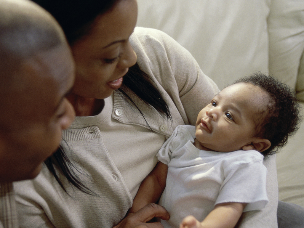 Black parents holding their baby