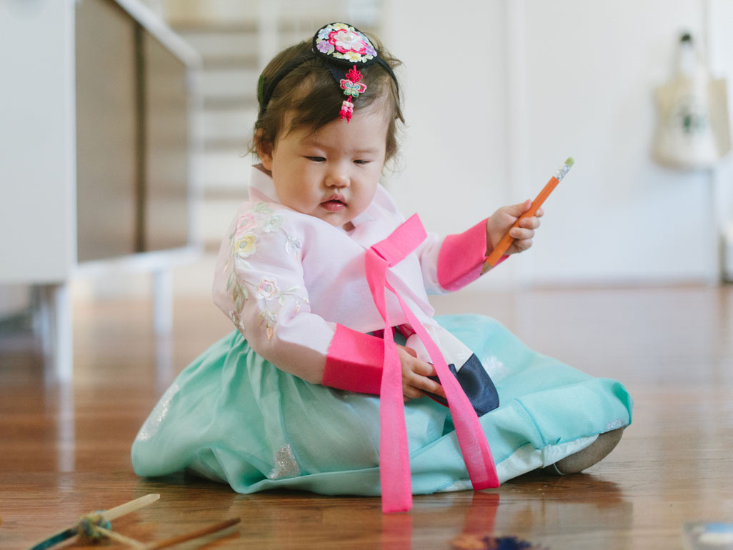 A Korean baby girl dressed in traditional clothing at her dol